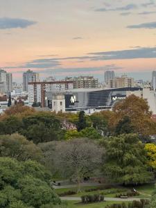 a view of a building in a city with trees at Chacarita Sunset l Andes Park in Buenos Aires