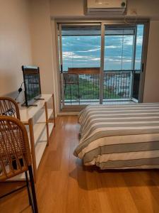 1 dormitorio con cama, escritorio y ventana en Chacarita Sunset l Andes Park en Buenos Aires