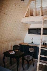eine Küche mit einem Tisch und Stühlen in einer Hütte in der Unterkunft MiLight in Aucugals