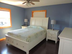 a bedroom with a bed and two night stands at Angel Rock Waterfront Cottages in Cape Vincent