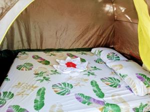 ein Bett in einem Zelt mit einer Blume darauf in der Unterkunft Zhaya's Beach & Cottages in El Nido