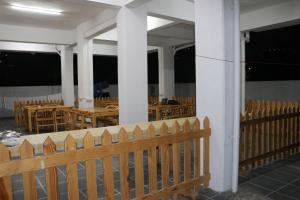 a porch with tables and chairs and a wooden fence at Ornate Service Apartments in Pune