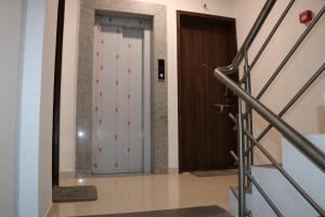 a hallway with a glass door and a staircase at Ornate Service Apartments in Pune
