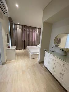 - une chambre avec un lit, un lavabo et un miroir dans l'établissement Hawana Forest Island Salalah, à Ma‘mūrah