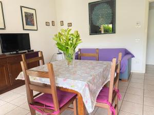 a dining room table with a vase of flowers on it at Gugliormella in Sirolo