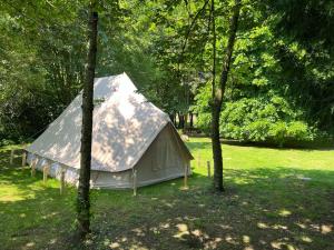 a tent in the middle of a field with trees at Superior Luxury Large Emperor Tent in Stoke Goldington
