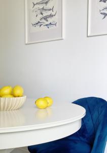 a white table with lemons and a blue chair at Mieszkanie Balticana in Władysławowo