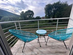 2 sedie blu e un tavolo sul balcone di Apartmani Vivami a Budua