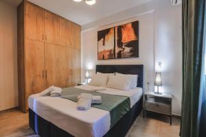 - une chambre avec un grand lit et des serviettes dans l'établissement Sunny Apts, à Saranda