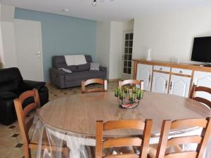 uma sala de estar com uma mesa e cadeiras e um sofá em Gîte 5-6 personnes « Chez Marlène »proche de Nigloland em Meurville