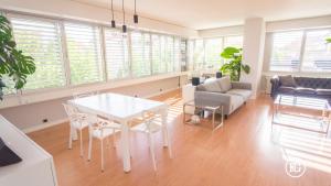 un soggiorno con tavolo, sedie e divano di Bernabéu - Cuzco - Eurobuilding 2 Luxury Apartment a Madrid