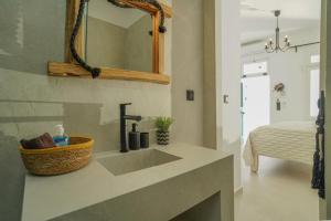 a bathroom with a sink and a mirror at Seabed Suites Mykonos in Mikonos