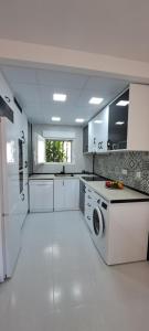 eine große weiße Küche mit Waschmaschine und Trockner in der Unterkunft APARTAMENTO HECO in Peñíscola