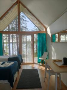 um quarto com duas camas e uma mesa e uma janela em Norwide - Hossan Lomakeskus em Hossa