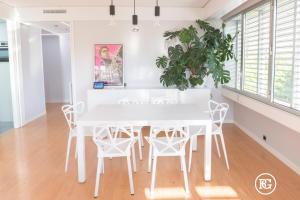 uma sala de jantar branca com uma mesa e cadeiras brancas em Bernabéu - Cuzco - Eurobuilding 2 Luxury Apartment em Madri