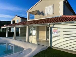 a house with a swimming pool in front of a house at Villa Niki in Soline