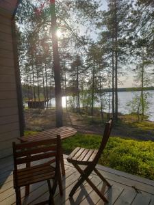 a porch with a bench and a table and a view of the water at Norwide - Hossan Lomakeskus in Hossa