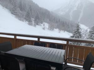 a table on a balcony with a snow covered mountain at L'orée des pistes in Oz
