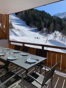 a table on a balcony with a view of a ski slope at L'orée des pistes in Oz