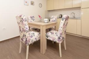 a dining room table and two chairs with flowers at Apartments Horizont in Budva