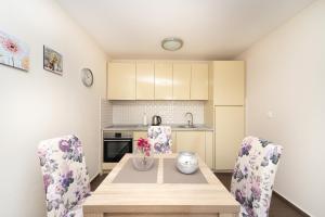 a kitchen with a wooden table and chairs at Apartments Horizont in Budva