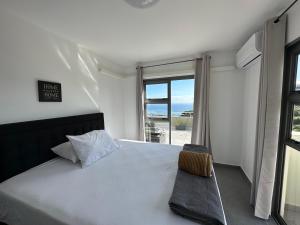 a bedroom with a bed with a view of the ocean at Iaorana Pamatai accomodation in Faaa