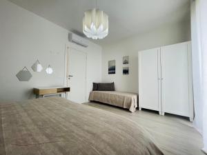 a white bedroom with a bed and a bed istg at A casa di Valentina, bilocale ai chiassarelli in Massa Marittima