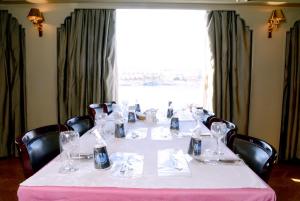a table with a white table cloth and wine glasses at Nile cruise every Monday 4 night Luxor Aswan -3nights every Friday Aswan Luxor in Aswan