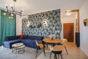 a living room with a blue couch and a table at Sunny Apts in Sarandë