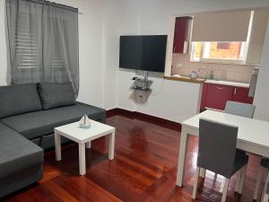 a living room with a couch and a table at Apartmani Kacola in Tučepi