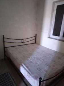 a small bed in a room with a window at Casa al mare in Santa Maria del Focallo