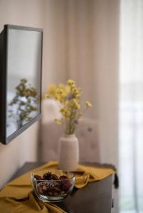 une table avec un vase et des fleurs dans un miroir dans l'établissement Athenian Dream Apartment-A Spacious Comfortable and Luxurious Apartment in a real Athenian neighborhood, à Athènes