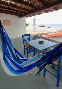 a blue hammock and a table and chairs on a patio at Villea Seaview Apartments in Skopelos Town