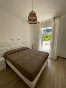 a bedroom with a large bed and a large window at Residence San Domenico in Ischia