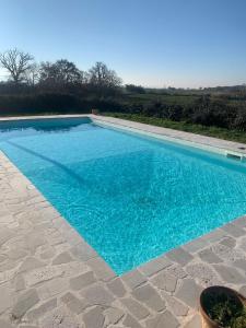 a swimming pool with blue water in a yard at Casale del Rosmarino - Suite Albicocca in Montefiascone