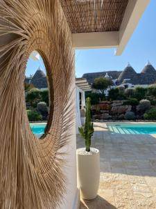 een cactus in een witte vaas naast een zwembad bij Borgo Fantese in Ostuni