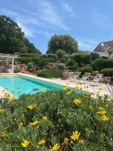 een tuin met een zwembad en bloemen bij Borgo Fantese in Ostuni