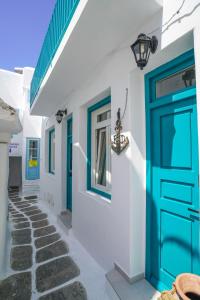 uma fila de casas brancas com portas azuis em Seabed Suites Mykonos em Míconos