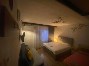 a small bedroom with a bed and a window at ZANI Hostel in Prizren