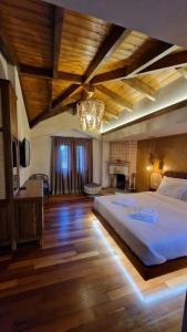 a large bedroom with a large bed and a fireplace at Bujtina Behram in Korçë