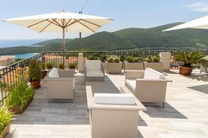 a patio with tables and chairs and an umbrella at Apartments Horizont in Budva