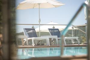 um grupo de cadeiras e um guarda-sol junto a uma piscina em Apartments Horizont em Budva