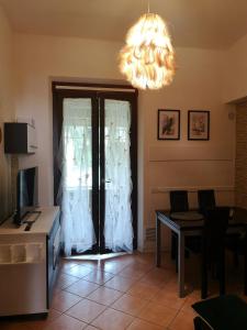 ein Wohnzimmer mit einem Kronleuchter und ein Zimmer mit einem Tisch in der Unterkunft Casa Ludo in Lucca