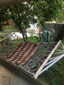 a metal bed in a yard with a tree at Lux-2-or-1- persons Irodion Edoshvili Street #15 in Kutaisi
