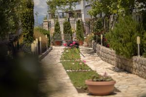 a garden with flowers and plants on a sidewalk at Apartments Horizont in Budva