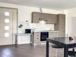 a kitchen with wooden cabinets and a table with chairs at Villa Eden a Levico Terme in Levico Terme
