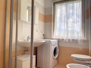 uma casa de banho com uma máquina de lavar roupa e um lavatório em Villa Eden a Levico Terme em Levico Terme