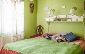 2 Bedroom Amazing Home In Vindeln في Vindeln: غرفة نوم بسرير مع جدران خضراء