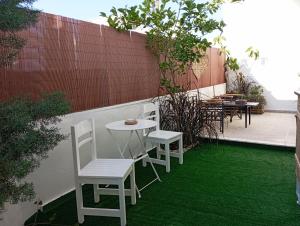 a patio with white chairs and a table and grass at ΤΟ ΔΙΑΜΕΡΙΣΜΑ ΤΗΣ ΜΑΙΡΗΣ or MARY'S APARTMENT in Paradeísion