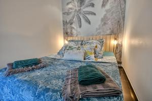een slaapkamer met een blauw bed met kussens erop bij The Beach Dream in Saint-Laurent-du-Var